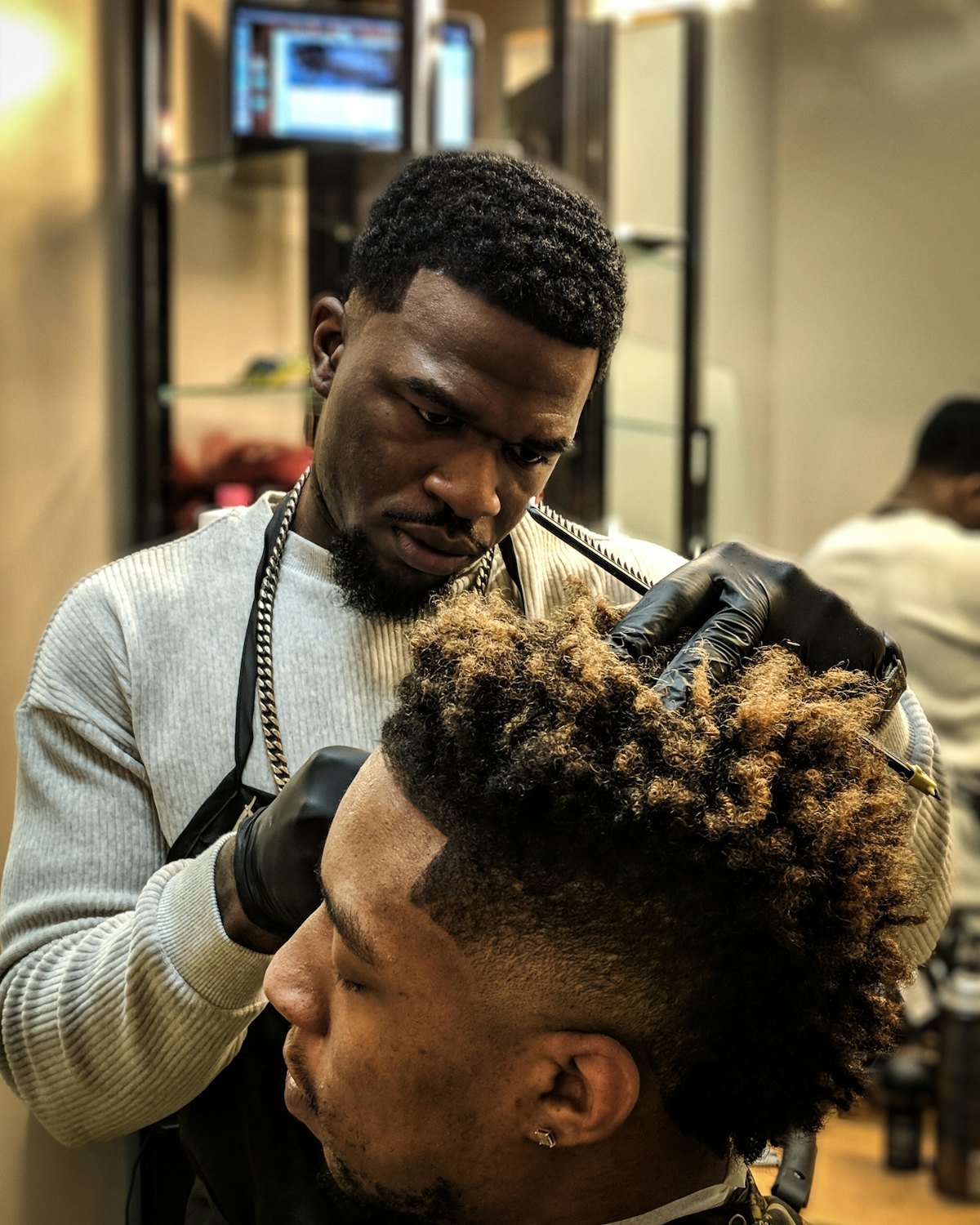 Reinat’s barber shaping a textured sponge-twist top with clippers