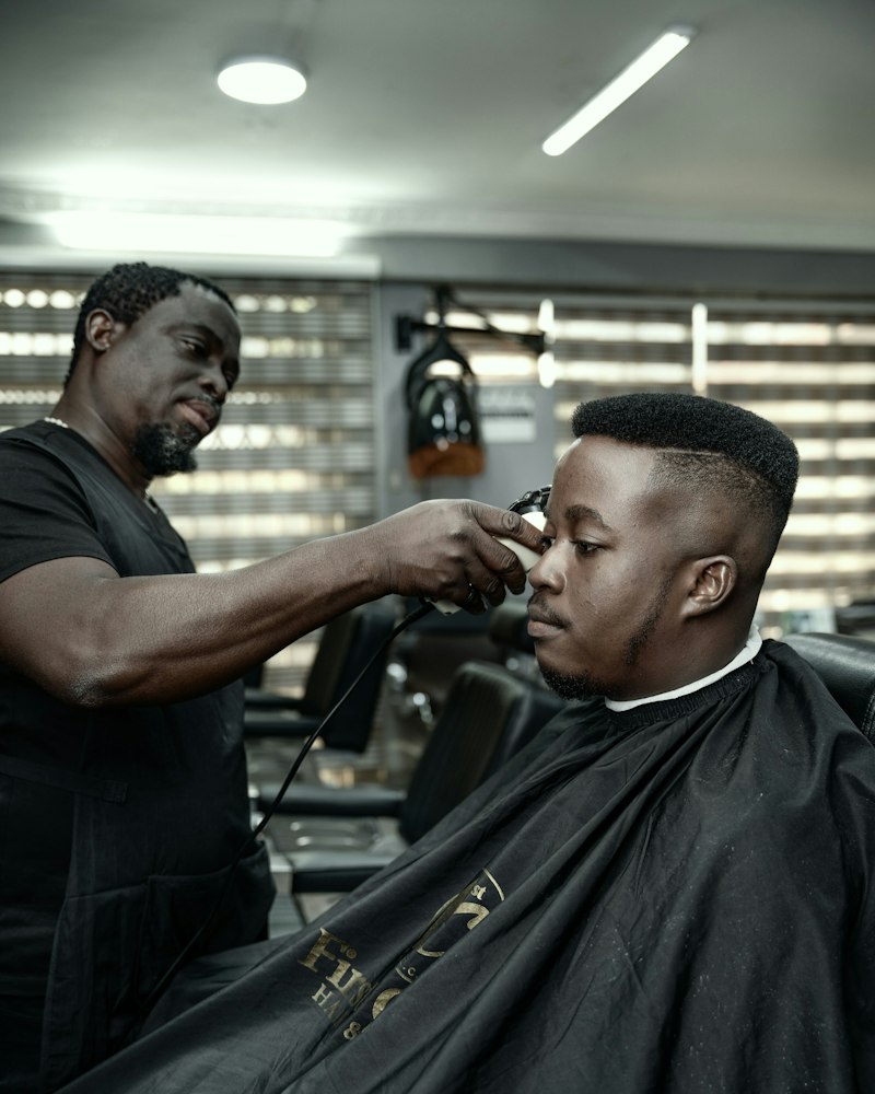 Barber finishing a client’s fade with clippers