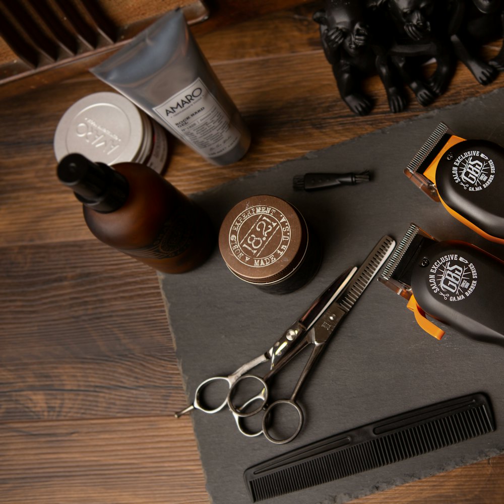 Clippers, scissors and grooming products laid out on a mat
